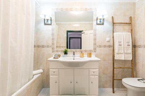 a bathroom with a white sink and a mirror at Herdade das Castas Nobres in Redondo