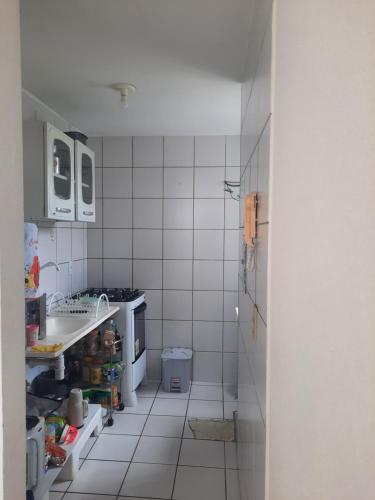 uma pequena cozinha com um lavatório e um frigorífico em Apartamento por temporada em Fortaleza