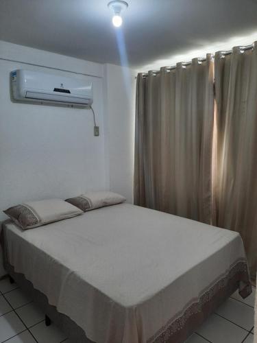 a bedroom with a bed and a air conditioner at Apartamento por temporada in Fortaleza