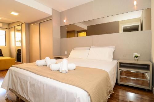 1 dormitorio con 1 cama blanca grande y toallas. en Apto Chique com Jacuzzi no Centro de Balneário Camboriú P2574, en Balneário Camboriú