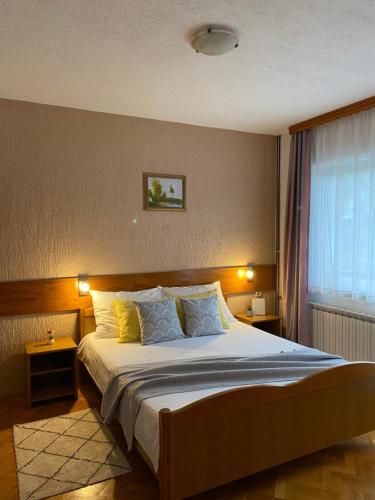a bedroom with a large bed with two night lights at M&N Zafran in Grabovac