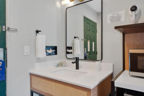 a bathroom with a sink and a large mirror at Garibaldi Inn at the Bay in Garibaldi