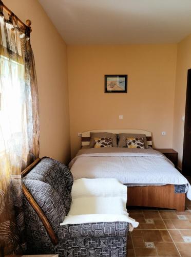 a bedroom with a bed and a couch in it at Apartment Perović in Nikšić