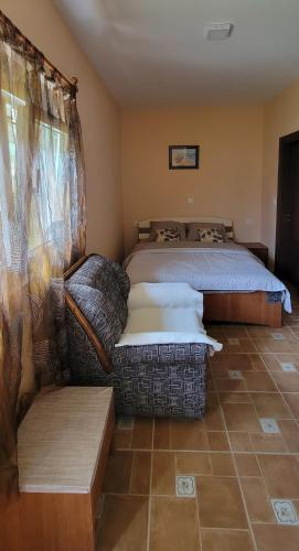 a bedroom with a bed and a couch at Apartment Perović in Nikšić