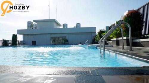 uma grande piscina em frente a um edifício em Hozby Skyview Setiabudi Suites em Sunggal