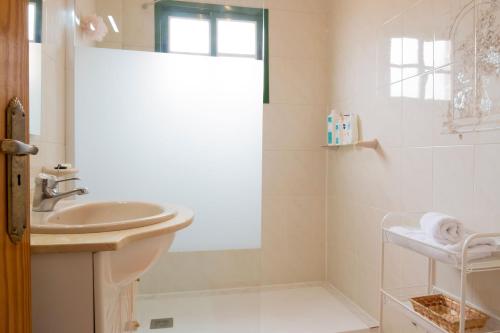 a white bathroom with a sink and a shower at LIVE GUANCHES DE CANDELARIA in Candelaria