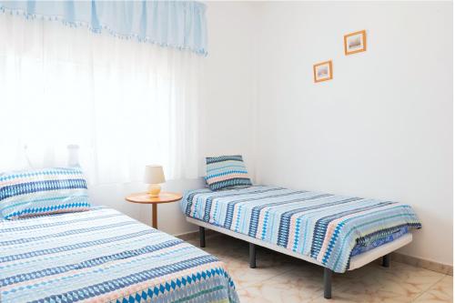 two twin beds in a room with a window at LIVE GUANCHES DE CANDELARIA in Candelaria