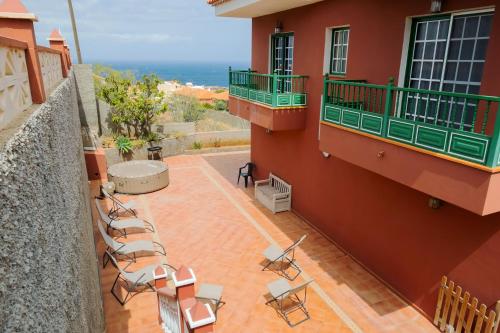 a balcony of a building with chairs and the ocean at LIVE GUANCHES DE CANDELARIA in Candelaria