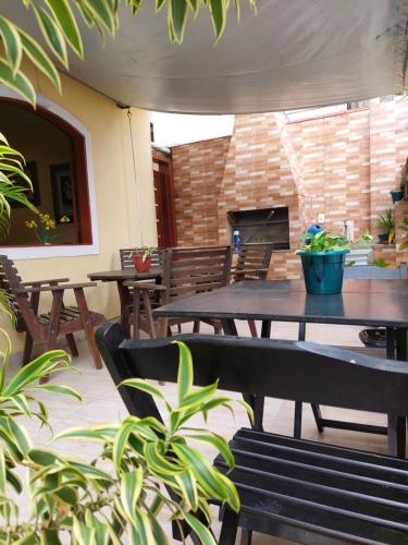 a patio with tables and chairs and a fireplace at Encantos do mar in Arraial do Cabo