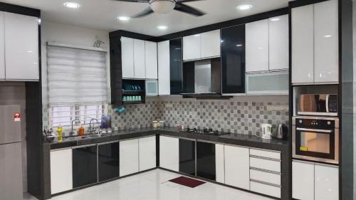 cocina con armarios blancos y ventilador de techo en Mysha KLIA F1 Homestay with pool,WiFi , Netflix en Kampong Chinchang