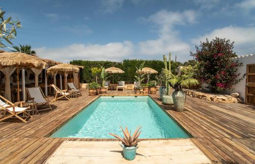 a pool on a wooden deck with chairs and a table at Can Aisha - Adults Only in Es Pujols