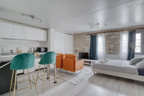 Il comprend une cuisine et un salon avec un lit et des chaises. dans l'établissement La Perle de Pontoise - studio proche Paris, à Pontoise