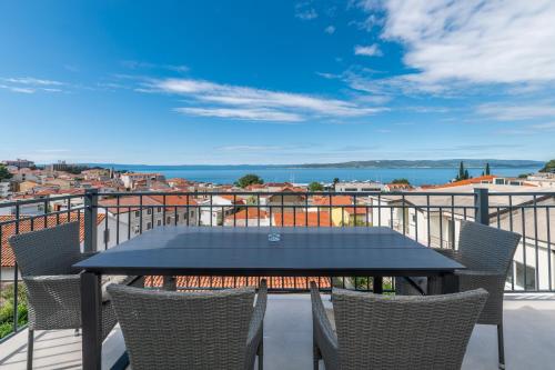 a table and chairs on a balcony with a view at Villa Senzen in Baška Voda