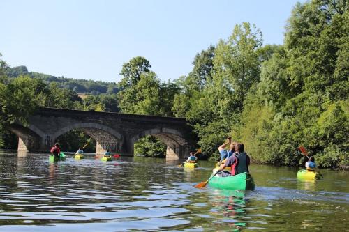 a group of people kayaking on a river with a bridge at Le Héron in Thury-Harcourt