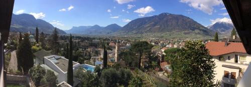 a view of a city with mountains in the background at Hotel Garni Hubertus in Tirolo
