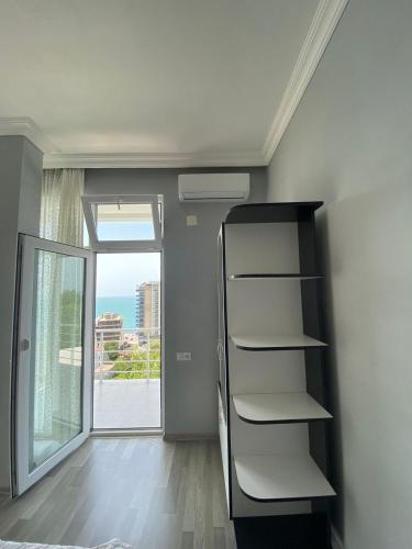 a empty room with a book shelf and a window at Temo's guest house in Kvariati in Kvariati
