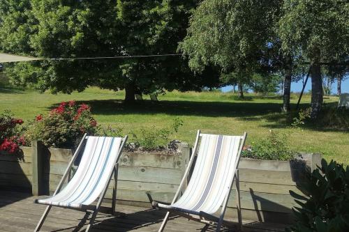 two white chairs sitting on a patio in a park at chambre à la campagne Saint André de Chalencon in Saint-André-de-Chalençon