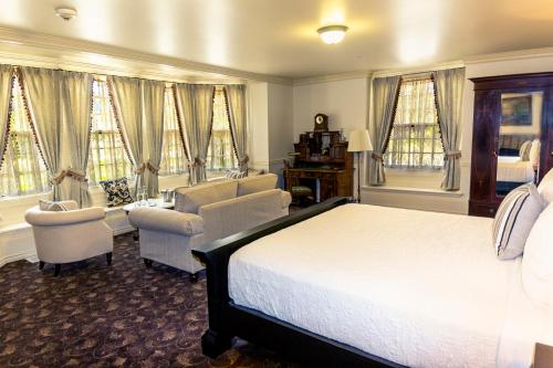 a bedroom with a bed and chairs and windows at Vermejo, a Ted Turner Reserve in Raton