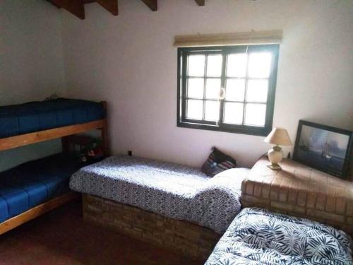 CASA EN MANANTIALES (Potrerillos, Mendoza) في بوتريريلوس: غرفة نوم بسريرين ونافذة