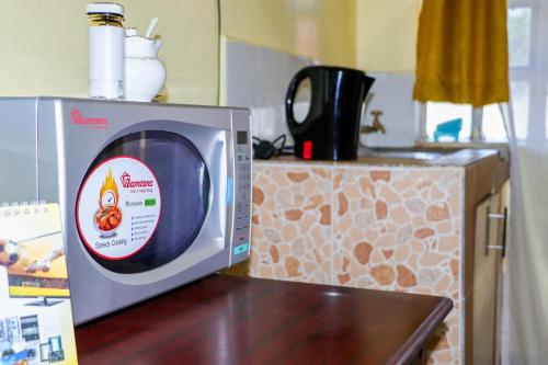 un four micro-ondes installé au-dessus d'un comptoir de cuisine dans l'établissement Trendy Homes Studio BnB, à Bungoma