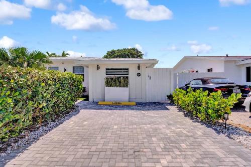 a white house with a car parked in front of it at Laguna @ Casa Del Sol in Fort Lauderdale