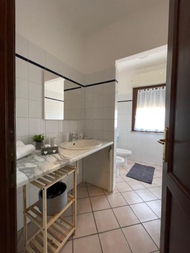 bagno bianco con lavandino e servizi igienici di La Cupola 129 a Olbia