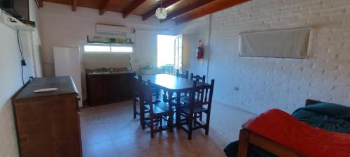 a kitchen and dining room with a table and chairs at Cabañas La Gringa in Potrero de los Funes