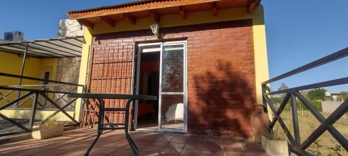 a chair on the deck of a house at Cabañas La Gringa in Potrero de los Funes
