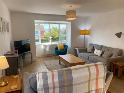 a living room with a couch and a tv at Larch Lodge in Totland