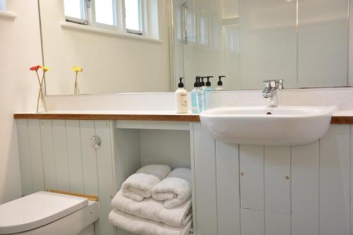 La salle de bains blanche est pourvue d'un lavabo et de toilettes. dans l'établissement Yew Tree Farm Stable, Worlingworth, à Worlingworth