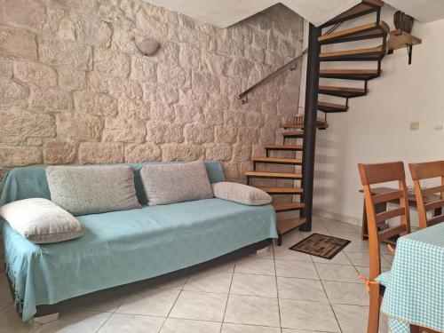a living room with a couch and a stone wall at Apartment Tonka in Trogir