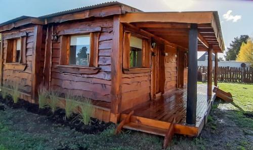 a log cabin with a porch and windows at La Cabaña de Sofi in Tandil