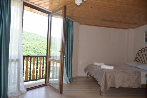 ein Schlafzimmer mit einem Bett und einem großen Fenster in der Unterkunft Guest House Ilto in Akhmety