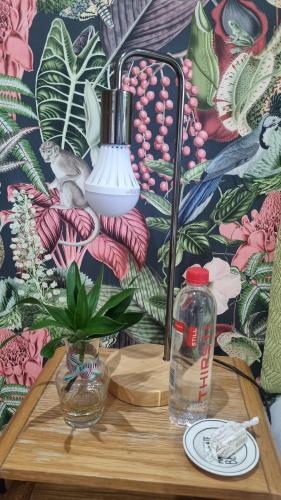 a table with a lamp and a bottle of water at Kingsley House Chalet in Ballito