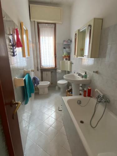 een badkamer met een bad, een wastafel en een toilet bij Appartamento a due passi dal mare! in Borghetto Santo Spirito