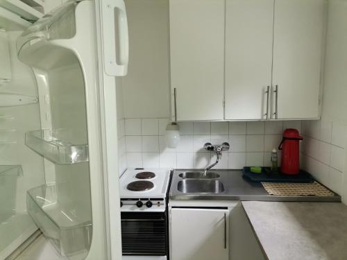 Una cocina blanca con estufa y fregadero. en Economy Escape, en Kouvola