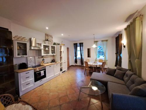 een keuken en een woonkamer met een bank en een tafel bij Gasthaus zum Fuchs - Familie Andrä in Hermagor