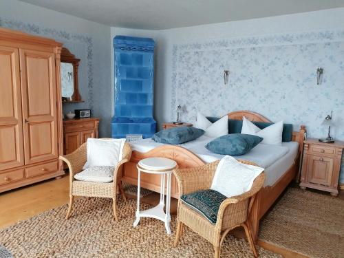 a bedroom with a bed with two chairs and a table at Landtraum im Traumland Mecklenburg in Warin