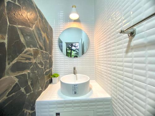 a bathroom with a sink and a mirror at Por jai’s House in Campson