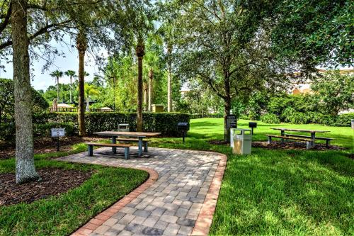 two picnic tables in a park with trees and grass at Vista Cay Resort by Millenium at Universal Blvd. in Orlando