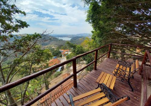 a wooden bench sitting on a wooden deck with a view at Pousada do Xerife in Caconde
