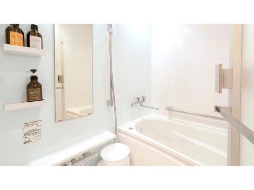 a bathroom with a tub and a toilet and a mirror at La'gent Hotel Okinawa Chatan Hotel and Hostel - Vacation STAY 59138v in Fuenzan