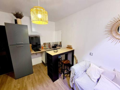 ein Wohnzimmer mit einer Küche mit einem Sofa und einem Tisch in der Unterkunft Appartement cosy et calme en Hyper-centre in Tarbes