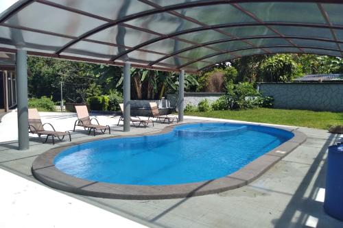 una piscina sotto un pergolato accanto alla piscina di Amazing Villa at Lake Arenal 2 a Tronadora
