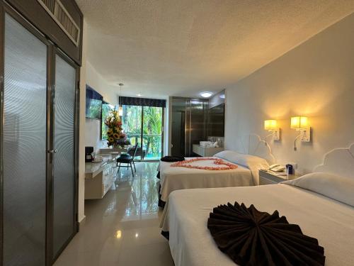a hotel room with two beds and a bathroom at Hotel Plaza Caribe in Cancún
