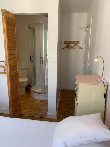 a bathroom with a shower and a toilet and a mirror at La Maison de la Plage in Trouville-sur-Mer