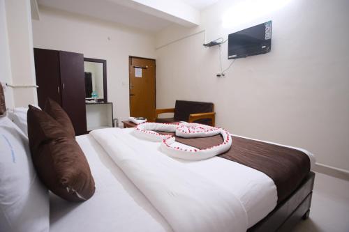 a bedroom with a bed with two pillows on it at Ganesh Guest House in Chennai
