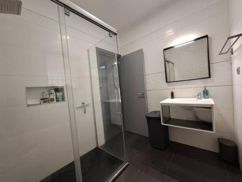 a bathroom with a shower and a sink and a mirror at Villa Ocean Waves in Aroeira