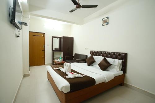 a bedroom with a large bed with two towels on it at Ganesh Guest House in Chennai