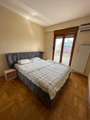 a bedroom with a bed and a window at Great location two bedroom apatment ''MAXIM'' in Podgorica